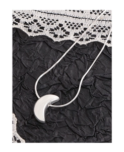 Macro shot of silver crescent moon pendant on a fine snake chain necklace