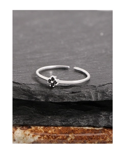 Détail macro d'une bague en argent S925 avec fleur en zircon noir sur pierre sombre