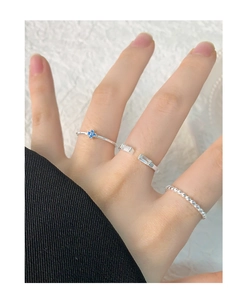 Vue détaillée du set de bagues en argent S925 avec fleur en zircon bleu et anneau perlé