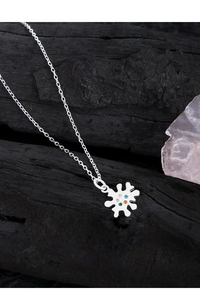 Macro detail of S925 silver necklace with colorful zircon petals on black background