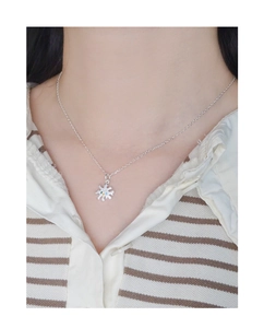 Close-up of S925 silver necklace with a sunburst pendant set with colorful zircons