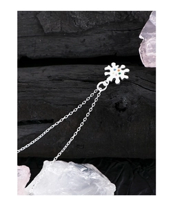 Macro detail of S925 silver necklace with colorful zircon flower pendant on dark texture