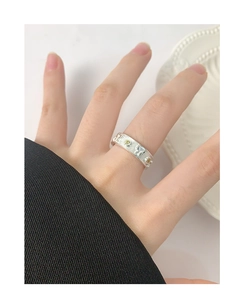 Macro view of wide silver ring with butterfly design and yellow zircon on model hand