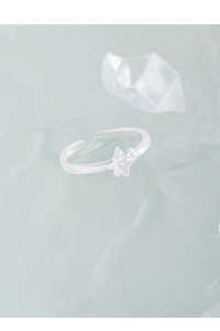 Macro view of sterling silver star ring on icy translucent base with sleek metal finish