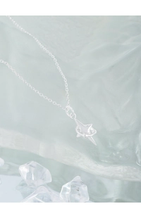 Vue macro du pendentif étoile croisée en argent S925 avec une finition métallique style Y2K