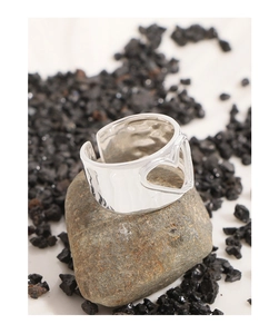 Macro shot of silver hammer texture ring with hollow heart design on stone