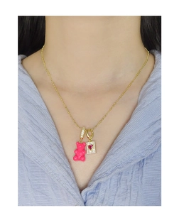 Detail of s925 gold chain with pink resin bear and sparkling red heart zircon pendant