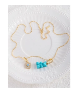 Detail of S925 silver golden chain with a blue bear and sparkling heart zircon pendant
