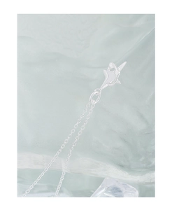 Vue macro du pendentif étoile argentée à quatre branches sur une chaîne délicate