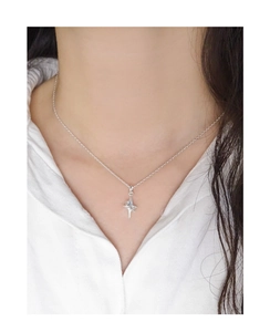 Détail d'un collier étoile en argent S925 porté par un mannequin en chemise blanche