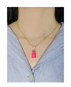 Detail of pink gummy bear pendant on gold bead chain necklace with zircon accents