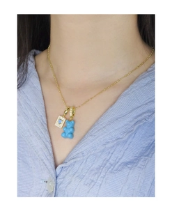 Detail of s925 silver necklace featuring a blue resin bear and zircon envelope charm