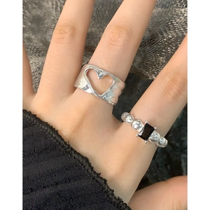 Irregular hollow heart ring and silver beaded ring set with black gemstone on hand