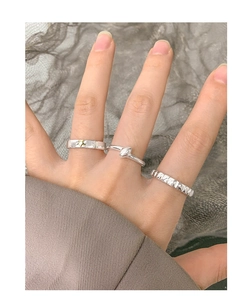 Close-up of three S925 sterling silver rings with star and texture detail on finger