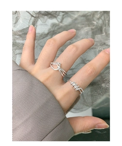Detail of S925 sterling silver twist and spiral rings on a finger for a minimalist look