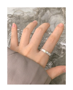 Close-up of S925 sterling silver open ring with gold star accent worn on finger