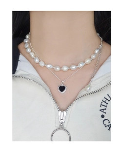 Detail of layered S925 silver necklace with baroque pearls and black heart pendant