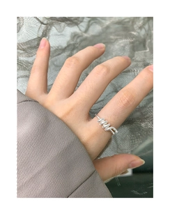 Close-up of minimalist silver S925 sterling silver spiral twist ring on female finger