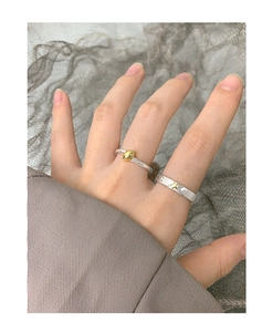Detail of silver S925 open rings featuring gold star relief and minimalist oval bean design