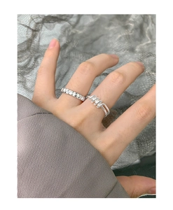 Detailed view of silver S925 geometric and spiral rings set on fingers for women
