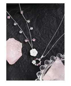 Macro detail of S925 silver flower necklace with pink zircon and natural shell petals