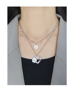 Gros plan du collier double couche en argent S925 avec pendentif cœur et détails floraux