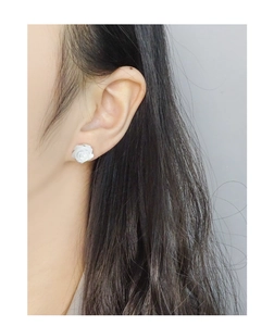 Vue rapprochée de boucles d'oreilles rose blanche portées pour un style élégant
