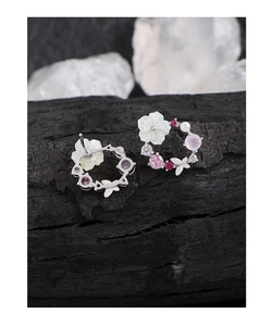 Detailed macro view of S925 silver floral earrings with shells and colorful zircons
