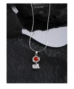Détail du collier en argent S925 avec pierres d'agate rouges et blanches sur roche