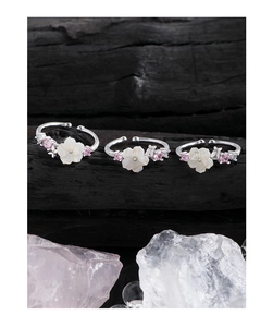 Detail of adjustable S925 silver rings with shell flowers and pink gemstone accents
