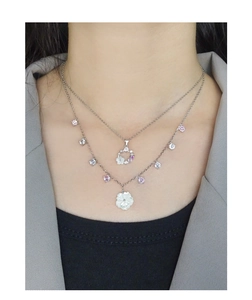 Close-up of layered S925 silver necklaces featuring shell flowers and zircon pendants