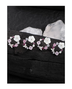 Macro detail of S925 silver flower earrings with shell petals and pink zircon accents