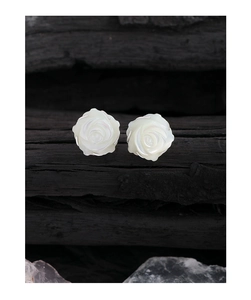Vue détaillée des boucles d'oreilles rose en nacre sur fond en bois texturé foncé