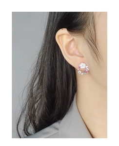 Detail of S925 silver flower earring with colorful zircon and natural shell on ear