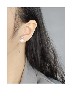 Detail view of flower drop earring with shell petals and long tassel on a female model