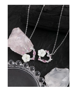 Détail du collier cœur en argent S925 avec pierres roses et fleurs en nacre sur noir