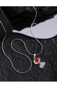 Détail du collier argenté à double pendentif avec agate rouge et pierre de lune