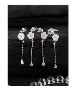 Macro shot of silver S925 flower earrings with shell petals and zircon tassel detail