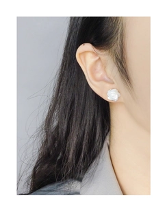 Gros plan de boucles d'oreilles en argent S925 avec roses sculptées en nacre blanche