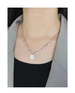 Detail of S925 silver necklace featuring shell flower pendant and zircon on a model