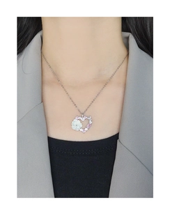 Collier cœur argenté avec fleur en nacre et zircons roses porté sur modèle