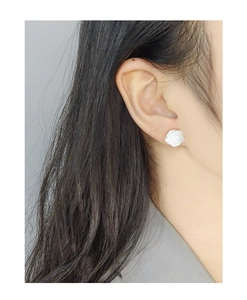 Gros plan de boucles d'oreilles rose blanche portées sur mannequin pour taille et détail