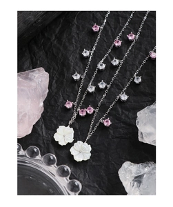 Macro shot of silver S925 necklace with shell flower pendant and zircon gemstones