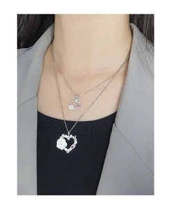 Detailed view of layered S925 silver necklace with shell flower and heart pendants
