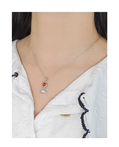 Détail d'un collier en argent S925 avec pendentif agate rouge sur le cou d'un modèle