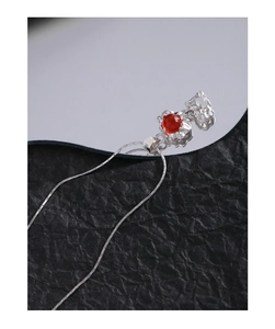 Macro d'un collier en argent S925 avec un pendentif rond en agate rouge à texture ridée