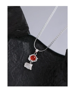 Détail macro du collier en argent S925 avec pendentif texturé et agate rouge brillante