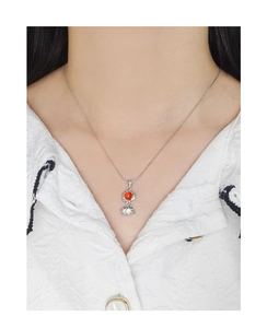 Gros plan du collier en argent S925 avec pierre d'agate rouge sur chemise blanche