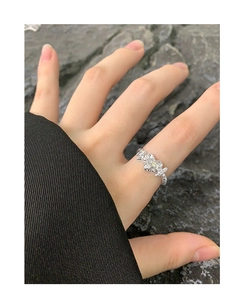 Macro detail of irregular pleated texture S925 silver ring with small clear inset stone
