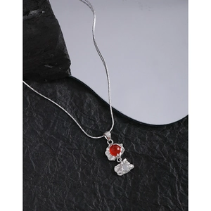 Collier en argent S925 avec pendentifs agate rouge et pierre de lune sur fond texturé